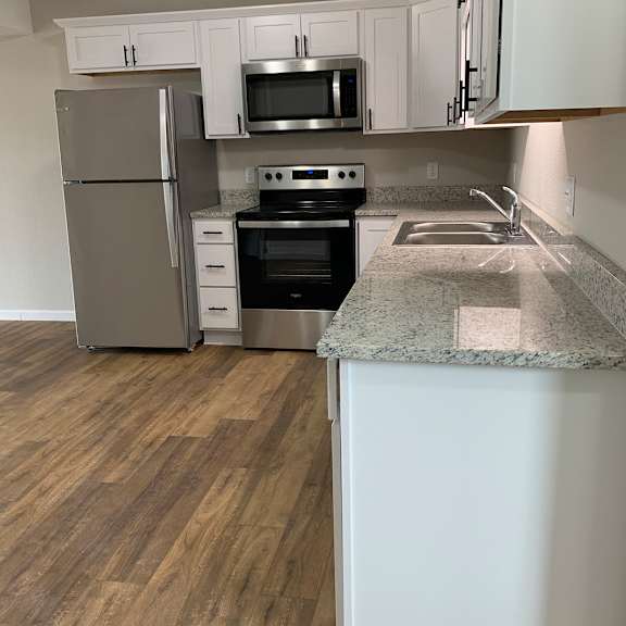 a kitchen with white cabinets and stainless steel appliances
