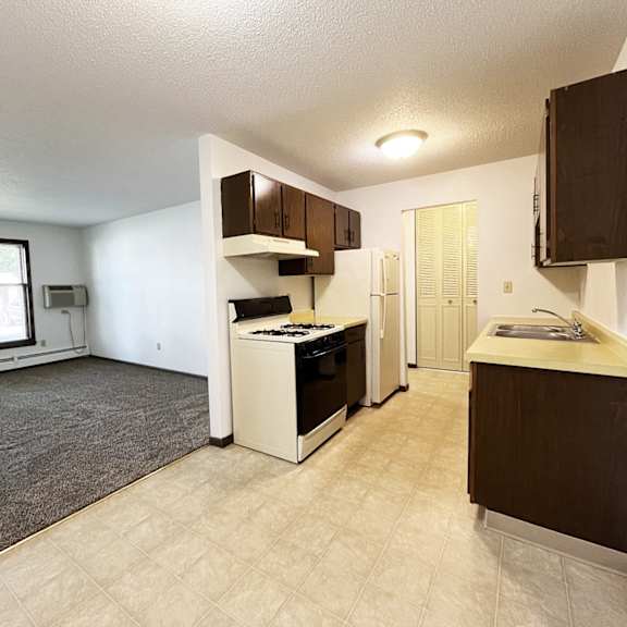 an empty kitchen and living room with a large window and