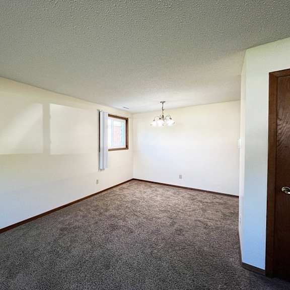 an empty living room with white walls and carpet