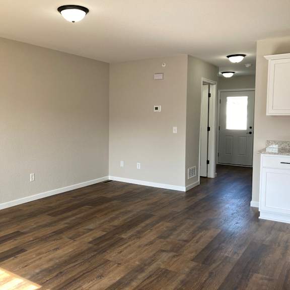 a bedroom with hardwood floors and grey walls