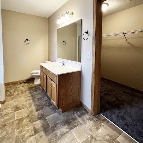 a bathroom with a toilet, sink, and mirror.