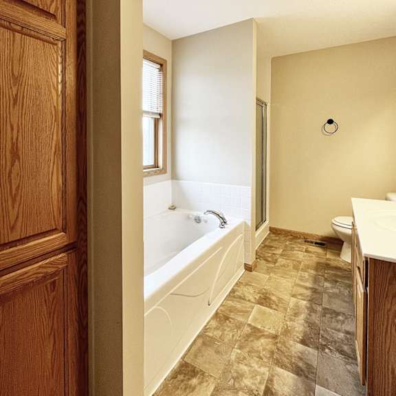a bathroom with a tub, toilet, and sink.