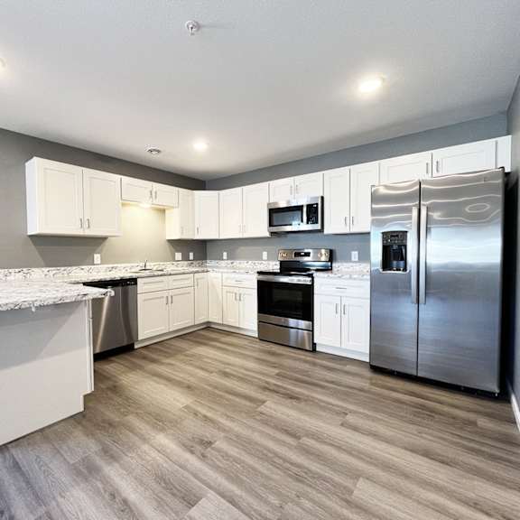 a kitchen with a marble countertop and stainless steel appliances.