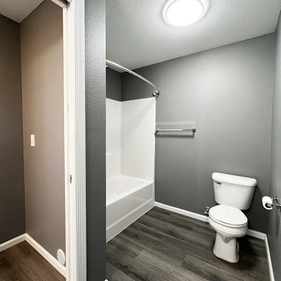 a white toilet sits in a bathroom with a walk-in shower.