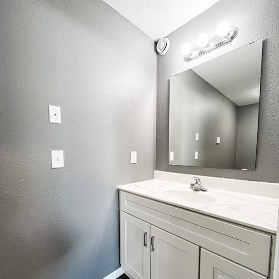a bathroom with a white sink and a mirror above it.