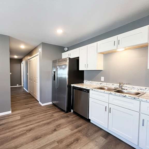 a kitchen with white cabinets and a stainless steel refrigerator.