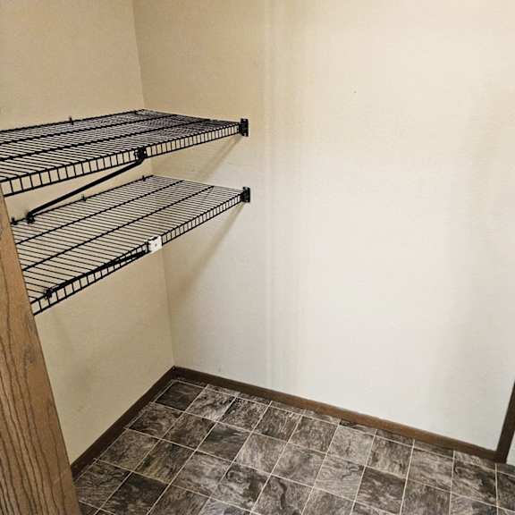 empty shelves in a room with a mirror on the wall.