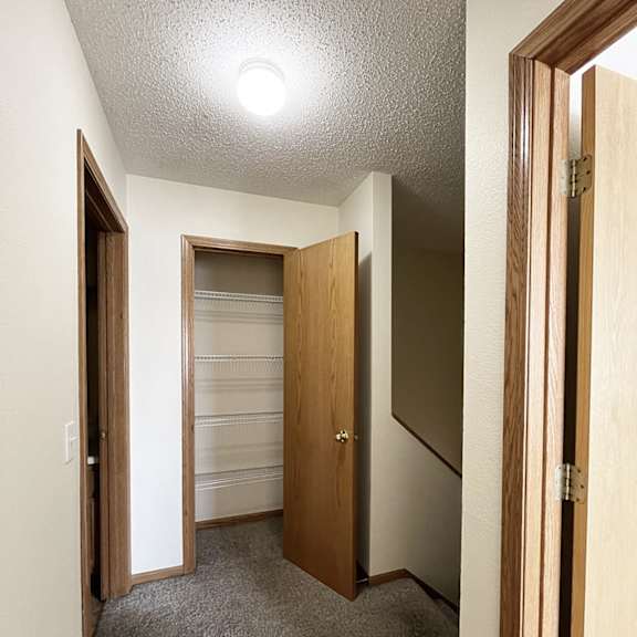 a walk in closet with a mirrored closet door and a door to a closet