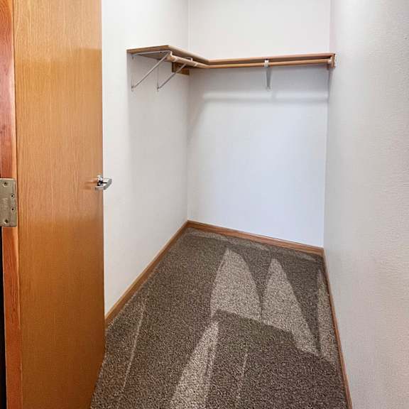 a hallway with a brown carpet and a wooden door.