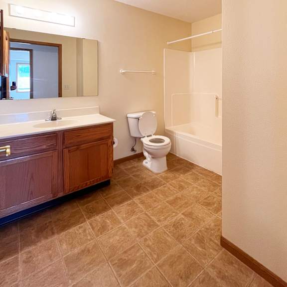 a bathroom with a toilet, sink, and mirror.