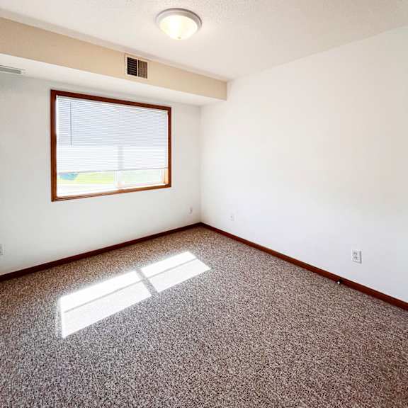 a room with a window and a carpet on the floor.