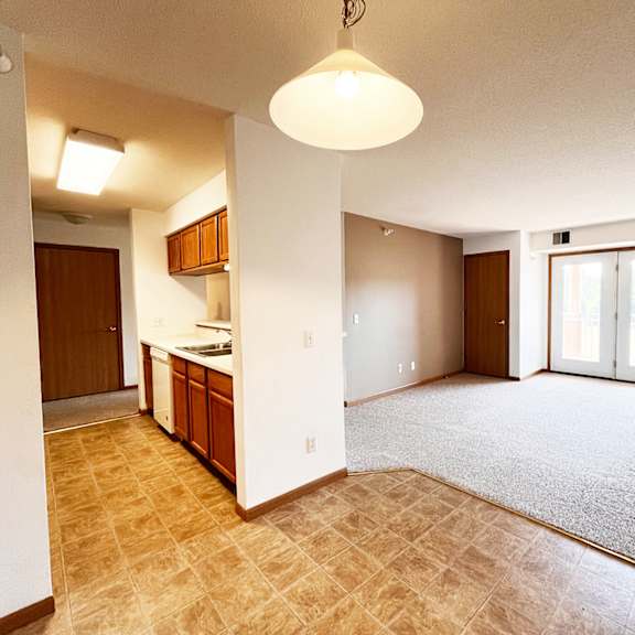 a kitchen area with a counter and cabinets is visible.