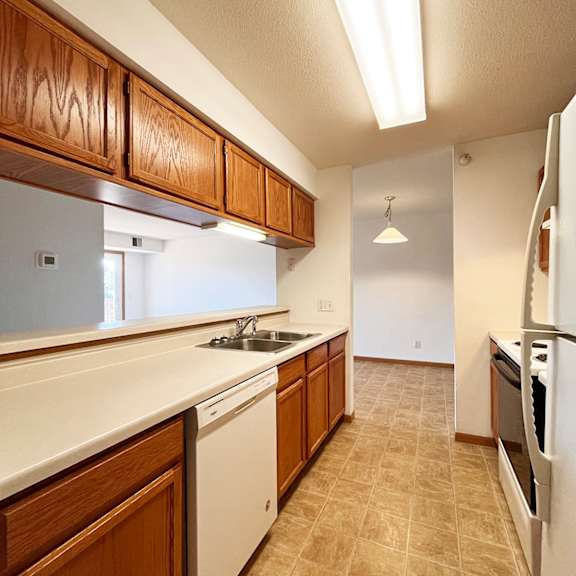 a kitchen with wooden cabinets and white appliances.