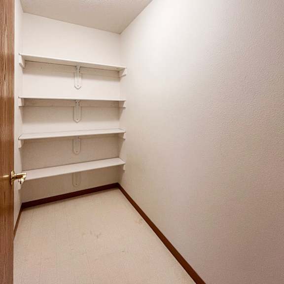 a white closet with a light on the ceiling.