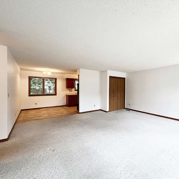 a large empty room with a blue door and a window.