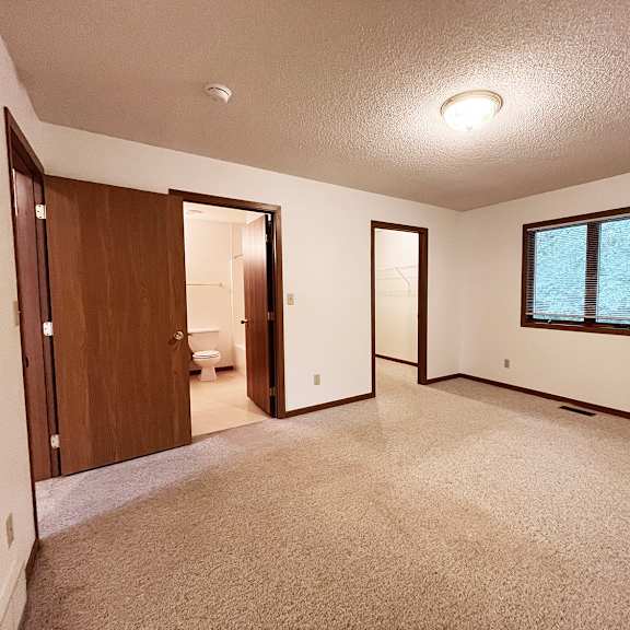 a room with a carpeted floor and a window.