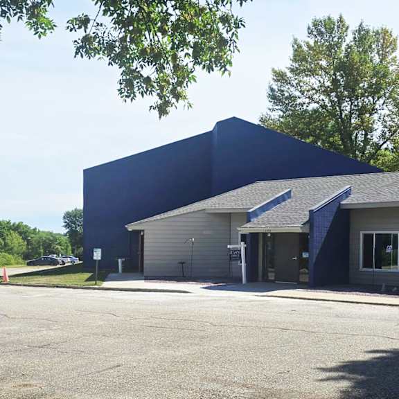 a blue building with a parking lot in front.
