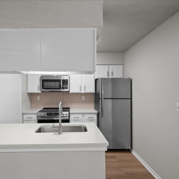 Thumbnail 8 of 9 a kitchen with a sink and a refrigerator