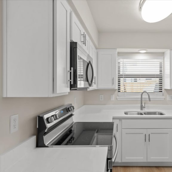 Thumbnail 5 of 10 a kitchen with white cabinets and stainless steel appliances
