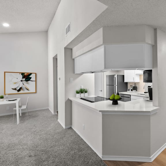 Thumbnail 3 of 13 an open kitchen and living room with white walls and white countertops
