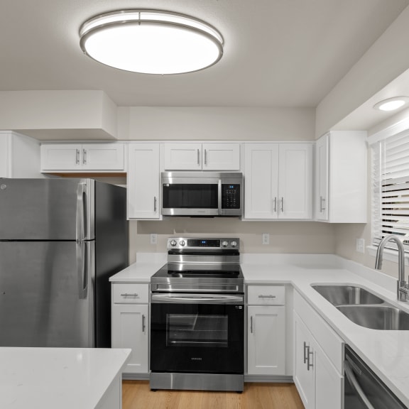 Thumbnail 5 of 13 a kitchen with white cabinets and stainless steel appliances