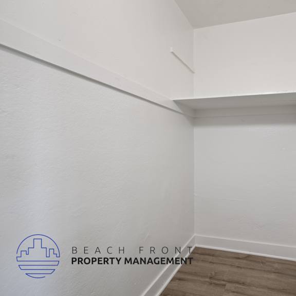 a walk in closet with white walls and a white door