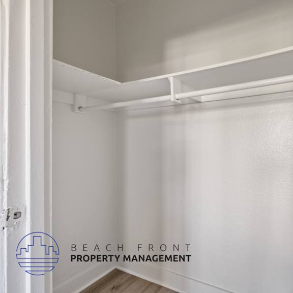 a walk in closet with a white wall and a white pipe on top of it