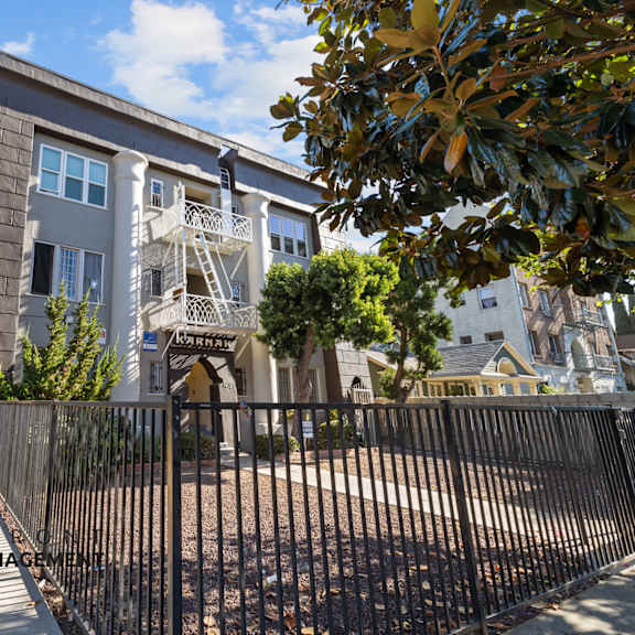 an apartment building with a gate and a fence in front of it