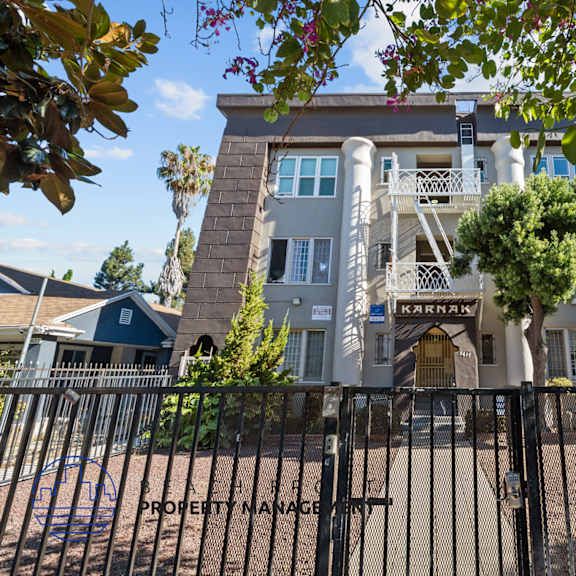 an apartment building with a fence and a gate in front of it