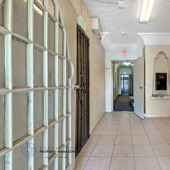 a long hallway with a door at the end and a sign above it.