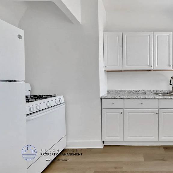 a kitchen with white appliances and cabinets.