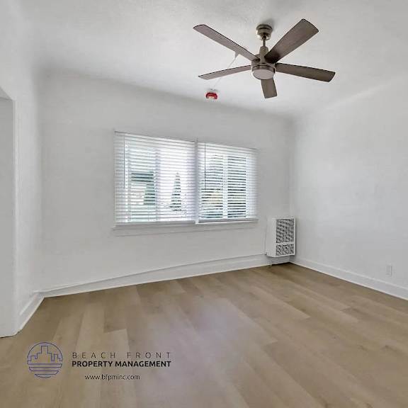 a room with a ceiling fan and a window with blinds.