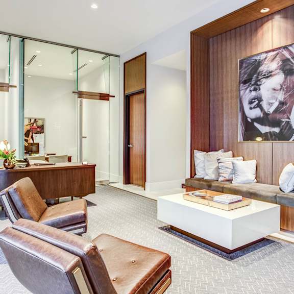 A modern living room with a brown leather chair and a white coffee table.