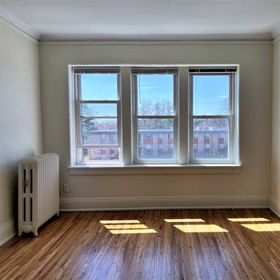 an empty room with three windows and an archway