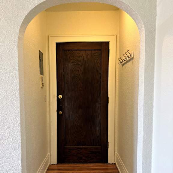 a hallway with a wooden door and an arched doorway