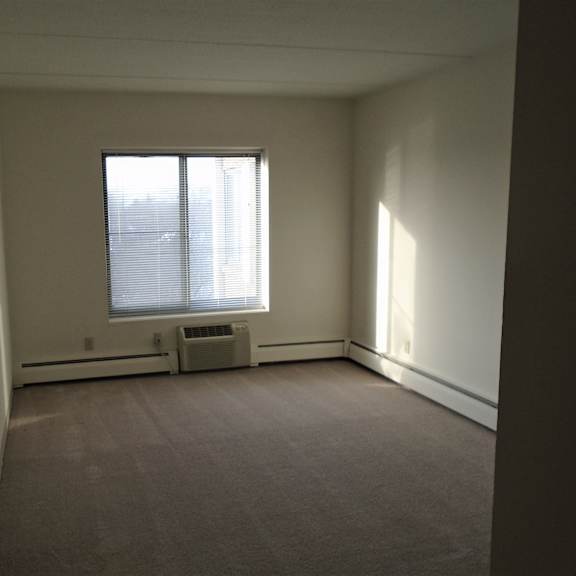 bedroom photo showing a/c unit and window at john snell apartments
