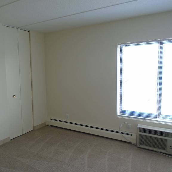 bedroom photo showing window and closed closet at john snell apartments
