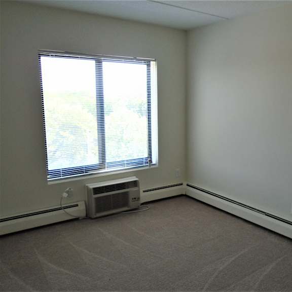 bedroom photo showing window and a/c unit at john snell apartments