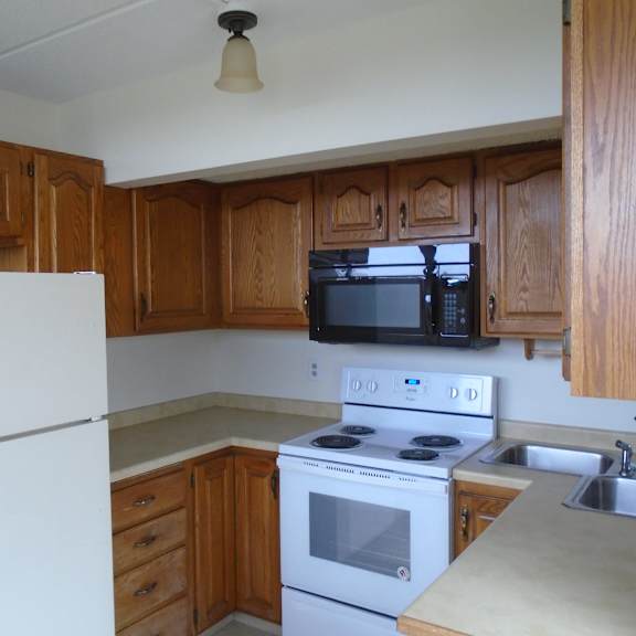 kitchen with microwave, oven, stovetop and fridge at john snell apartments