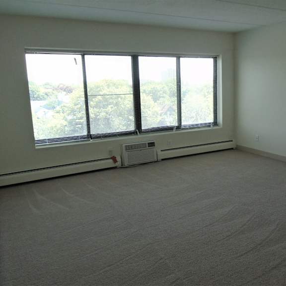 living area with large window and a/c unit at john snell apartments