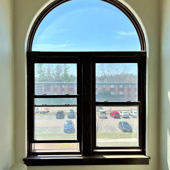 an arched window with a view of a parking lot