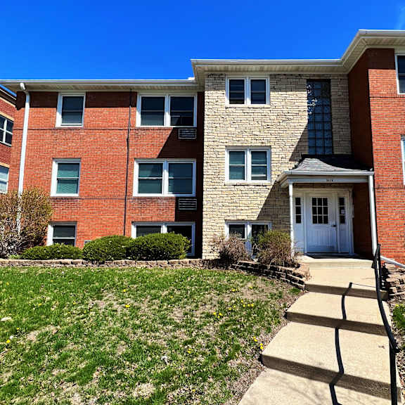 a brick apartment building with a blue sky in the background