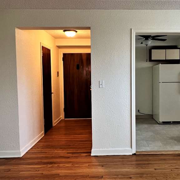 an open door leading to a kitchen and living room