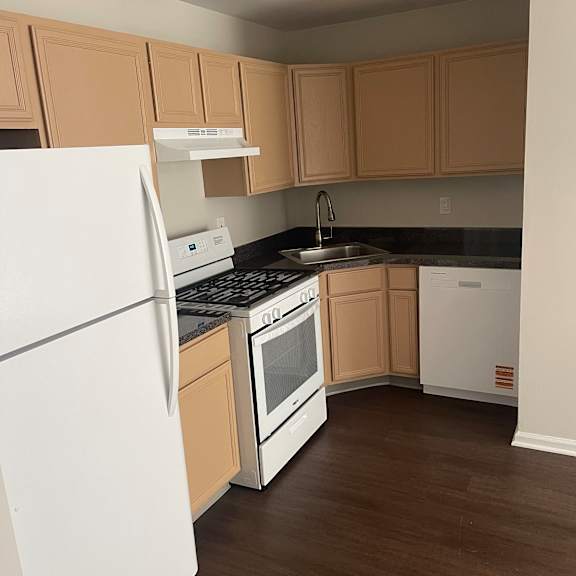 a white refrigerator is in a kitchen with wooden cabinets.