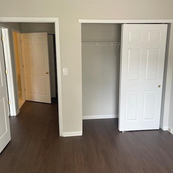 a white cabinet with a door open revealing a wooden drawer.
