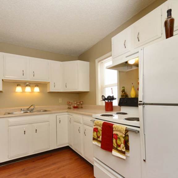 A kitchen with white cabinets and a white refrigerator.