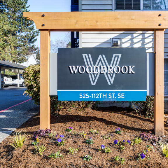 a wooden sign in front of a house