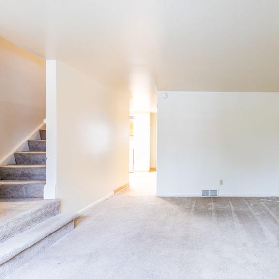 a room with a staircase and a light on the wall.
