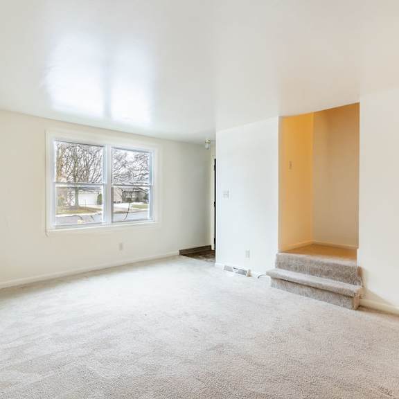 a room with a carpeted floor and a window.