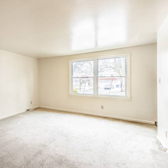 a room with a carpeted floor and a window.